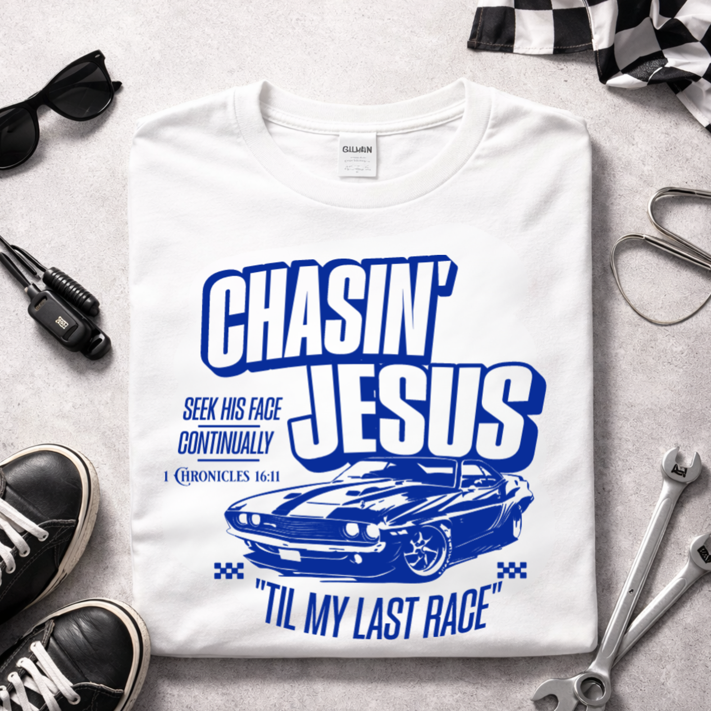 Folded white Chasin Jesus Til My Last Race Christian t-shirt with blue muscle car graphic inspired by 1 Chronicles 16:11